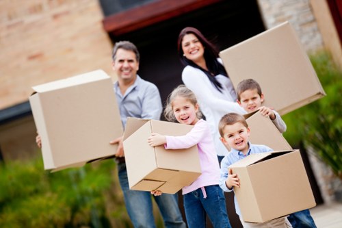 Removal team handling boxes and furniture in an East London flat